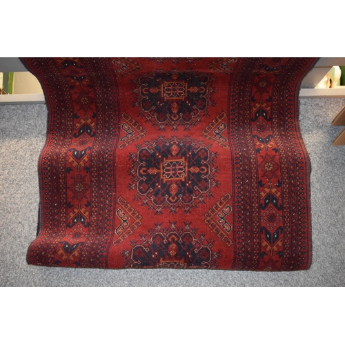 76 - A oriental / middle-eastern runner carpet / rug in deep reds, blues, oranges and cream. 83cm x 390cm... 