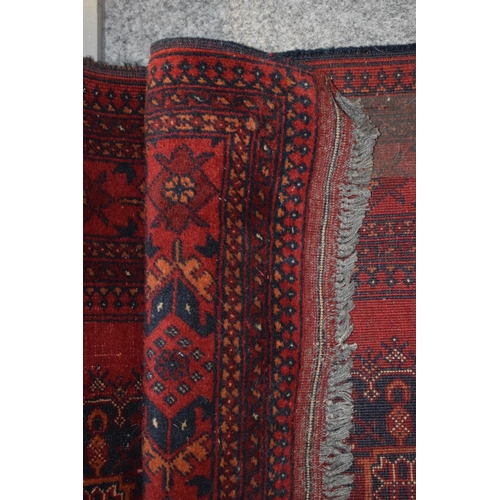 76 - A oriental / middle-eastern runner carpet / rug in deep reds, blues, oranges and cream. 83cm x 390cm... 