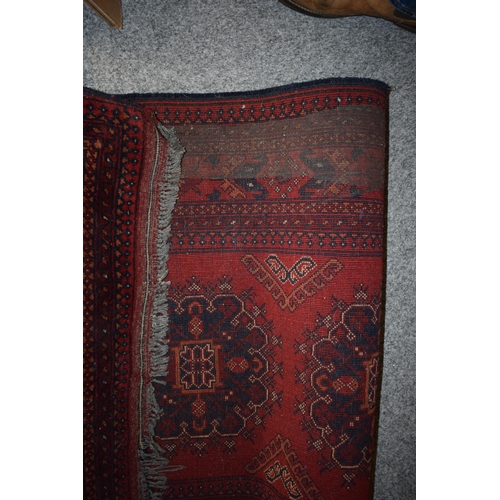 76 - A oriental / middle-eastern runner carpet / rug in deep reds, blues, oranges and cream. 83cm x 390cm... 