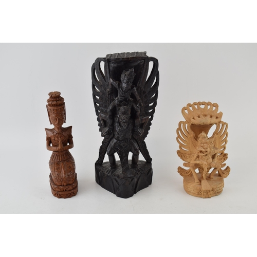 215 - Three carvings of deities from Bali. In different woods. (3) Height 25cm.