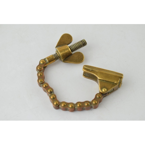 197 - Antique brass novelty bottle top remover, tension and screw type movement, 14cm long.