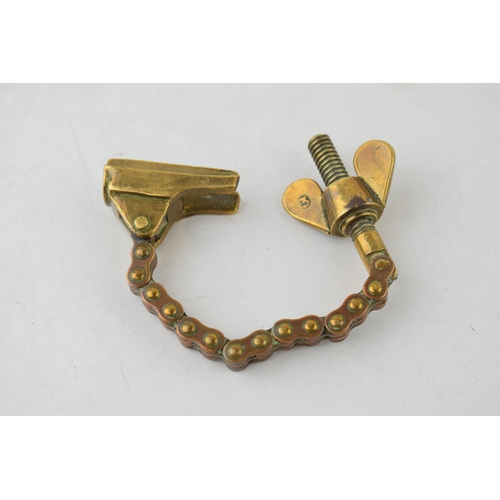 197 - Antique brass novelty bottle top remover, tension and screw type movement, 14cm long.