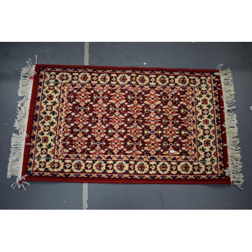183 - A Persian style hearth rug in red blues and creams. 59cm x 108cm.