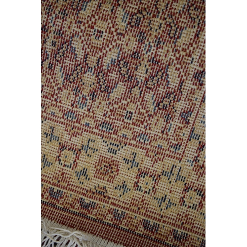 183 - A Persian style hearth rug in red blues and creams. 59cm x 108cm.