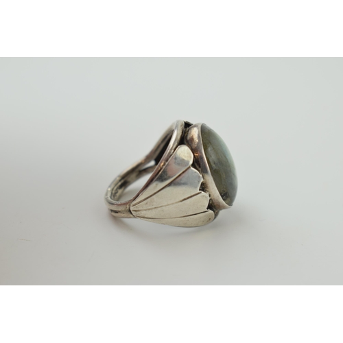 192 - A silver ring with oval moonstone. Ring size R. (Gross weight 10.5 grams).