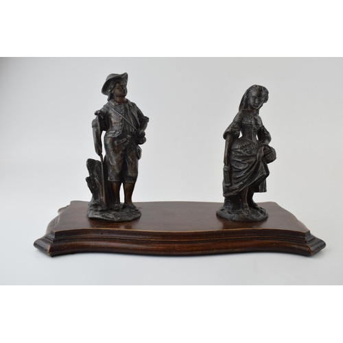 202 - Two spelter figures mounted on a wooden base. Height 19cm.
