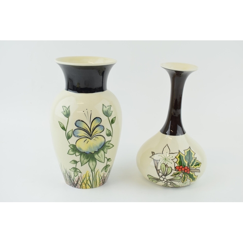 28 - An early pair of Lorna Bailey tubelined vases, one in the Pansies pattern, and the other with holly ... 