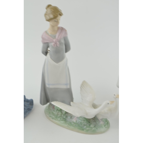 54 - A trio of figures to include a Lladro girl 4820 with a Nao girl with geese and a girl in a frilly dr... 