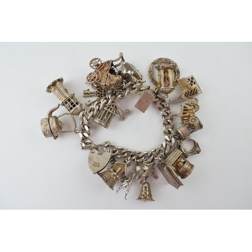 297 - Hallmarked silver charm, heavy, with charms to include a pram, a church, a well, a windmill and othe... 