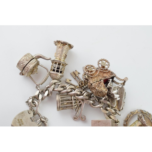 297 - Hallmarked silver charm, heavy, with charms to include a pram, a church, a well, a windmill and othe... 