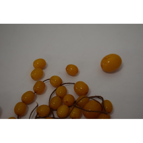 310 - Butterscotch amber or similar material graduated necklace beads. Weight 84 grams.