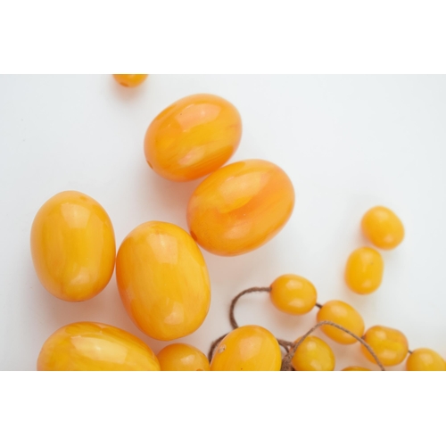 310 - Butterscotch amber or similar material graduated necklace beads. Weight 84 grams.