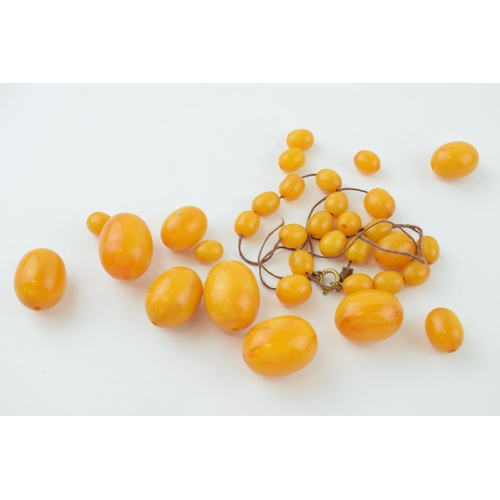 310 - Butterscotch amber or similar material graduated necklace beads. Weight 84 grams.