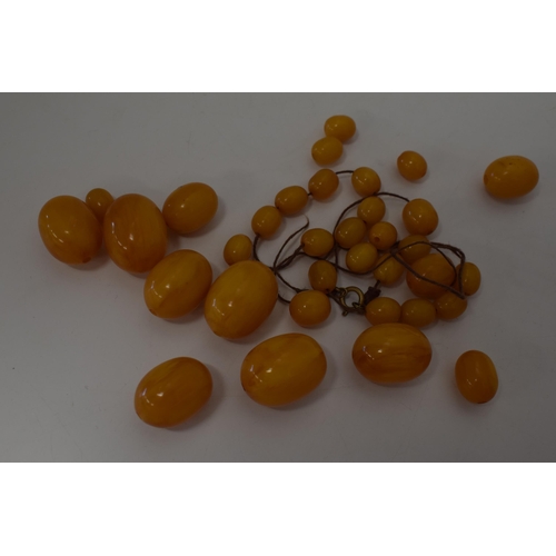 310 - Butterscotch amber or similar material graduated necklace beads. Weight 84 grams.