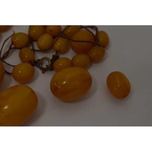 310 - Butterscotch amber or similar material graduated necklace beads. Weight 84 grams.