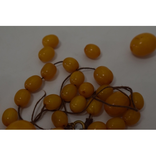 310 - Butterscotch amber or similar material graduated necklace beads. Weight 84 grams.