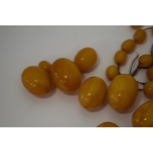 310 - Butterscotch amber or similar material graduated necklace beads. Weight 84 grams.