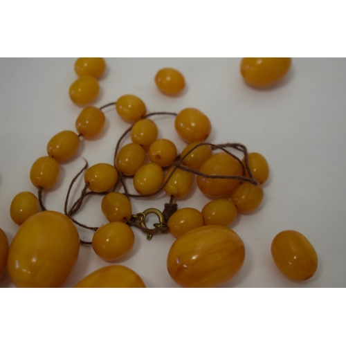 310 - Butterscotch amber or similar material graduated necklace beads. Weight 84 grams.