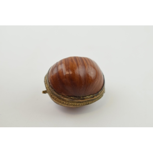 313 - A miniature purse made form a hazelnut shell with brass hinge and mount. 2.5cm.