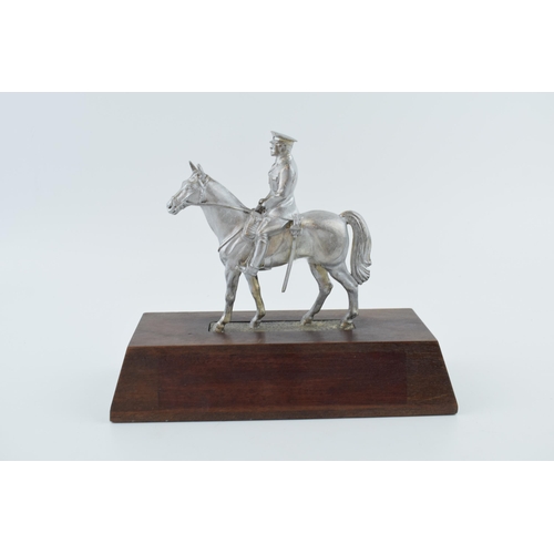 330 - A pewter military man on horse back on wooden base. Height 20cm.