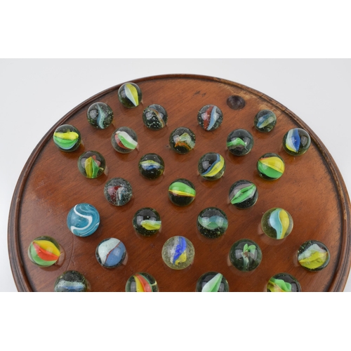 357 - An antique solitaire board with associated marbles. Diameter 30cm.