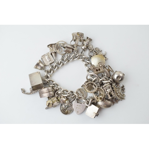 297A - Heavy silver charm bracelet to include an American football, a fish, a boat, a teapot and others, 11... 