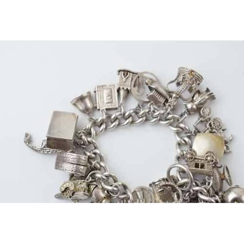 297A - Heavy silver charm bracelet to include an American football, a fish, a boat, a teapot and others, 11... 