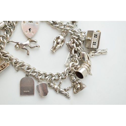 297D - Silver charm bracelet with a church, a bear, people, a tankard and others, 81.6 grams.