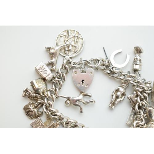 297D - Silver charm bracelet with a church, a bear, people, a tankard and others, 81.6 grams.