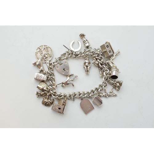 297D - Silver charm bracelet with a church, a bear, people, a tankard and others, 81.6 grams.