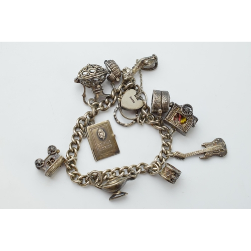 297E - Silver charm bracelet with a guitar, a carriage, a lamp and others, 64.2 grams.