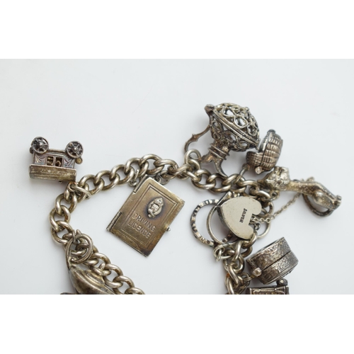 297E - Silver charm bracelet with a guitar, a carriage, a lamp and others, 64.2 grams.