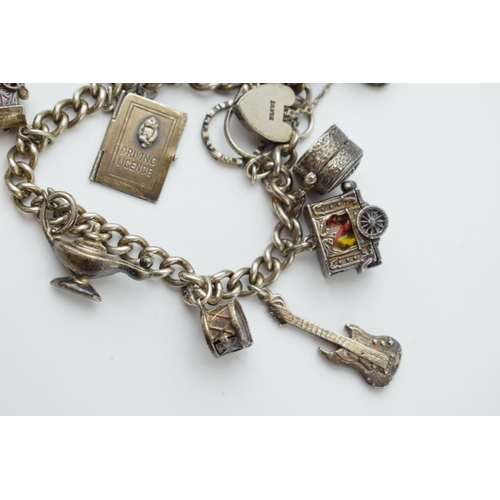 297E - Silver charm bracelet with a guitar, a carriage, a lamp and others, 64.2 grams.