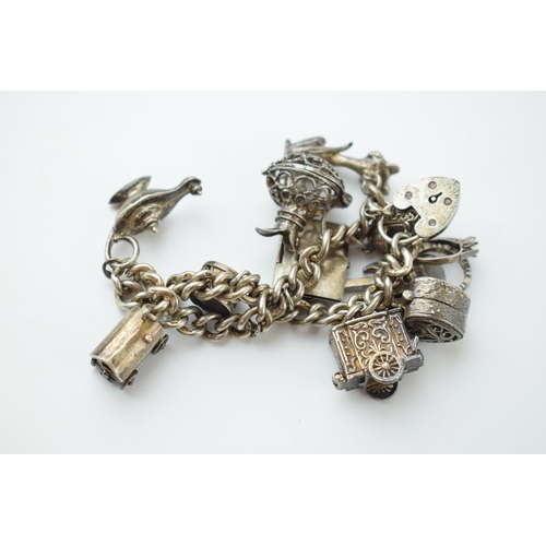 297E - Silver charm bracelet with a guitar, a carriage, a lamp and others, 64.2 grams.