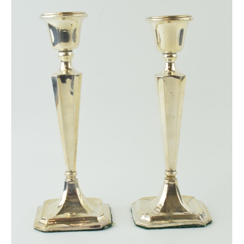 591 - A matched pair of silver candlesticks, with shaped bases, loaded, to include a Birmingham and Cheste... 