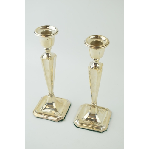 591 - A matched pair of silver candlesticks, with shaped bases, loaded, to include a Birmingham and Cheste... 