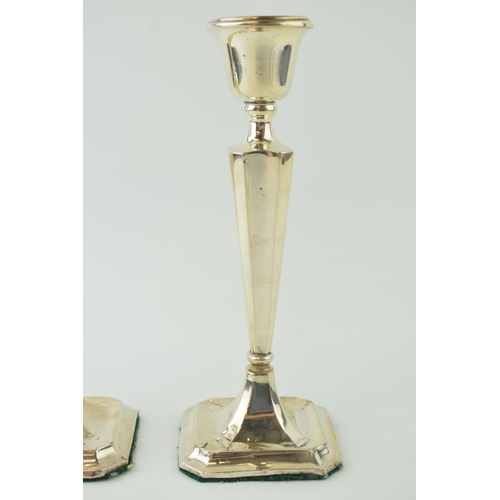 591 - A matched pair of silver candlesticks, with shaped bases, loaded, to include a Birmingham and Cheste... 