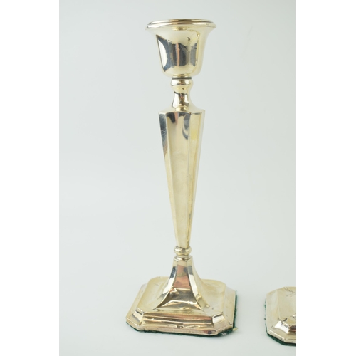 591 - A matched pair of silver candlesticks, with shaped bases, loaded, to include a Birmingham and Cheste... 