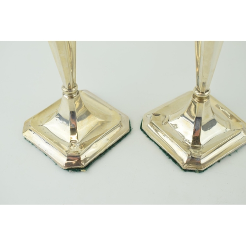 591 - A matched pair of silver candlesticks, with shaped bases, loaded, to include a Birmingham and Cheste... 