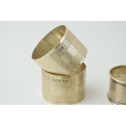 602 - A collection of silver napkin rings of varying forms / designs, to include 2 pair and 3 singular rin... 