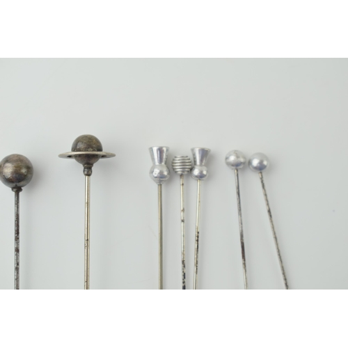 608 - A collection of hatpins to include two ornate silver examples and other white metal examples (9).