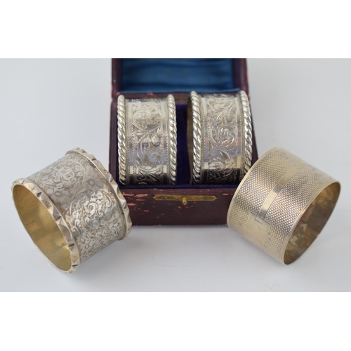 642 - A cased set of silver napkin rings together with two silver napkin rings. 119.5 grams.