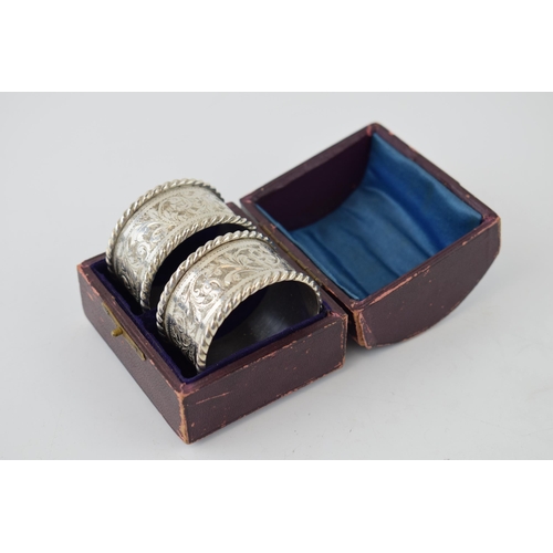 642 - A cased set of silver napkin rings together with two silver napkin rings. 119.5 grams.