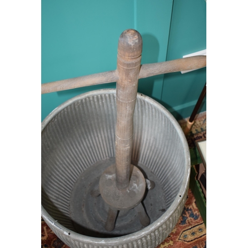 340 - A vintage galvanised dolly tub with original wooden dolly. Height 54cm.