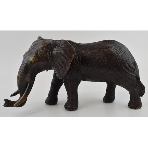 366 - Large contemporary bronzed figure of a walking elephant, with two tusks, 30cm long.