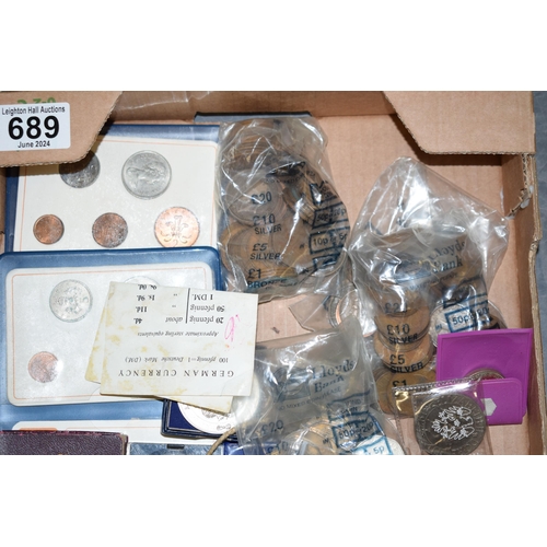 689 - A collection of UK and foreign coinage to include commemorative crowns, old 50ps, coin sets, and ear... 