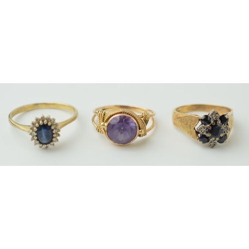 534 - A trio of 9ct gold rings to include a sapphire and illusion set diamond floral ring, an amethyst exa... 