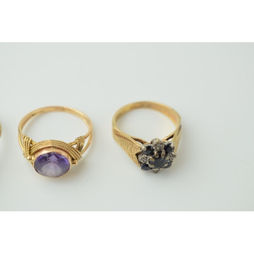 534 - A trio of 9ct gold rings to include a sapphire and illusion set diamond floral ring, an amethyst exa... 