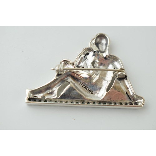 537 - Sterling silver brooch in the form of a sitting lady, stone set, 12.3g, 48mm wide.