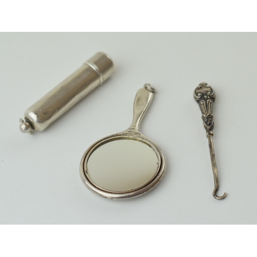 116 - Miniature silver mirror, Birmingham 1910, with a silver buttonhook and a silver tube box, Birmingham... 